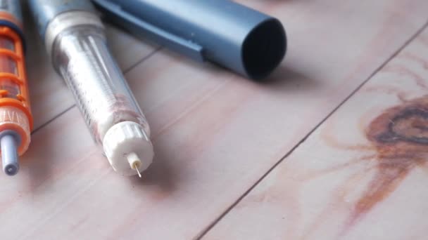 Muchos bolígrafos de insulina en el fondo de la mesa, de cerca — Vídeos de Stock