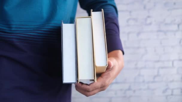 Hand hält Stapel von Büchern mit Kopierraum — Stockvideo