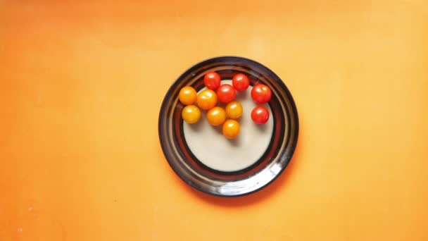 Poner tomate cereza colorido en el plato en la mesa — Vídeos de Stock