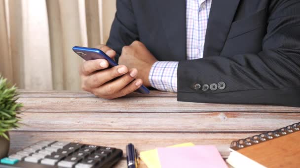 Zakenman hand met behulp van smart phone op kantoor bureau — Stockvideo