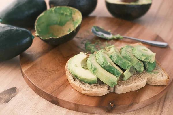Авокадо на ломтике коричневого хлеба на столе — стоковое фото