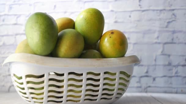 Świeże zielone mango w misce na stole — Wideo stockowe