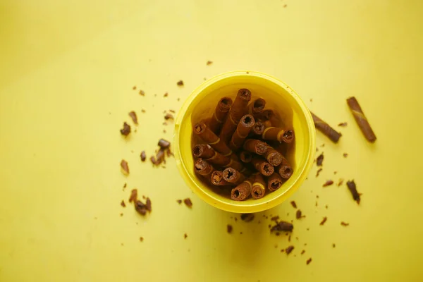 Mango smak wafel rolka czekolada w plastikowym pojemniku na żółtym tle — Zdjęcie stockowe