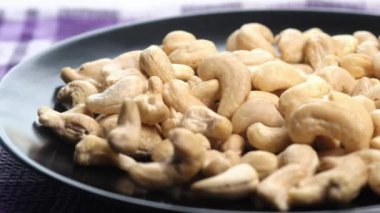 Kaju fıstığının yavaş çekimde tabağa düşmesi. 