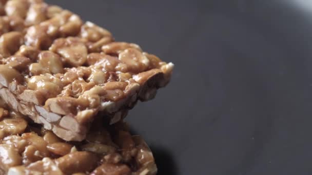 Nozes de ervilha barra doce em um prato de perto — Vídeo de Stock