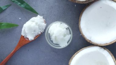 Hindistan cevizi yağlı kaşık ve siyah arka planda fındık 