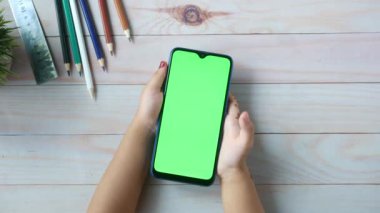 Masada akıllı telefon kullanan kız çocuğunun düz kompozisyonu 
