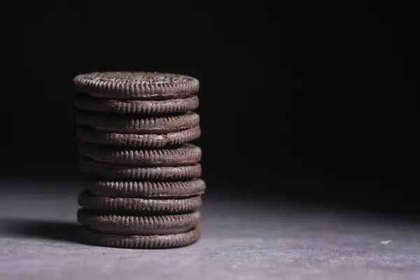 Close up de biscoitos de chocolate doce contra fundo preto — Fotografia de Stock