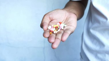 İlaç kutusundan dökülen ilaçlı adam eli. 