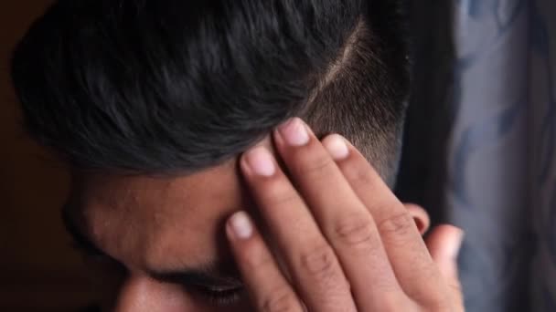 Vue latérale de l'homme coiffant les cheveux avec peigne sur fond noir, — Video