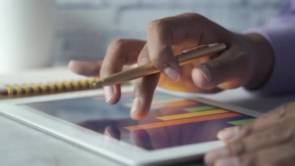 Adam el ile ofis masasında dijital tablet üzerinde çalışıyor, kendi yarattığı grafiği kullanarak. — Stok video