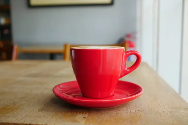 Close up de caneca de café de cor vermelha na mesa no café — Fotografia de Stock