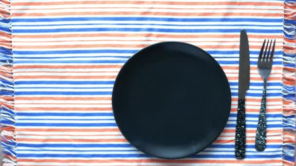 Red tulip flower and cutlery on plate on table — Stock Video