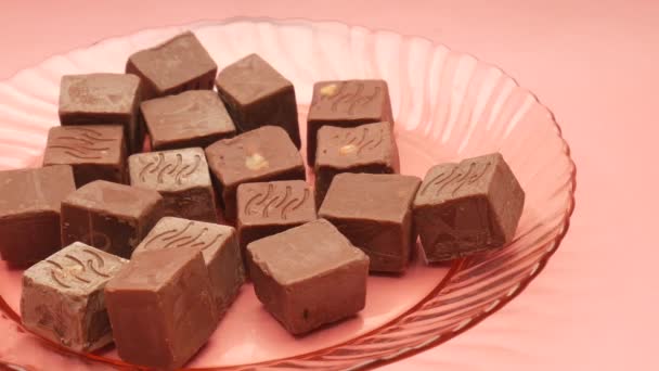 Dark chocolate on a plate on pink background — Stock Video