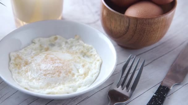 Huevo escalfado en un plato con leche en la mesa — Vídeo de stock