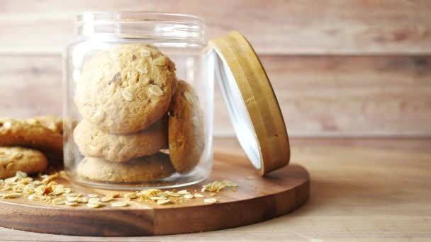 Pila de galletas enteras en un frasco sobre fondo de madera — Vídeos de Stock