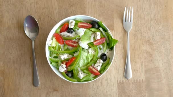 Vista superior da salada grega em uma tigela na mesa. — Vídeo de Stock