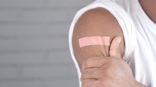Opatrunek samoprzylepny na ramieniu młodego mężczyzny — Wideo stockowe
