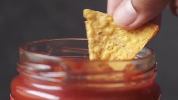 Nachos dompelen in een chili sauzen — Stockvideo