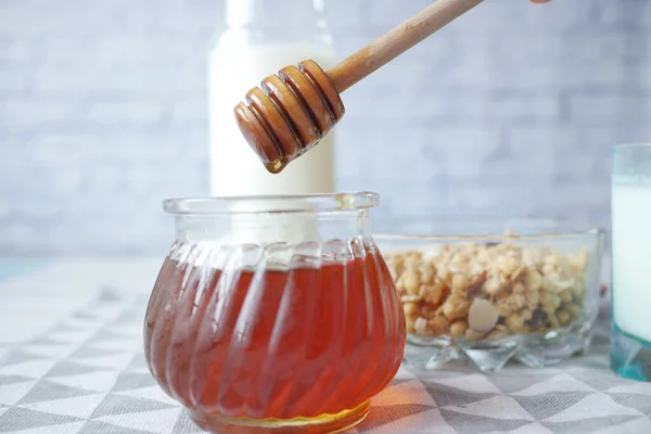 Close up of fresh honey with spoon on table — стоковое фото