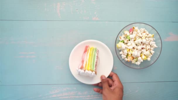 Ломтик торта, пончики и попкорн на столе — стоковое видео
