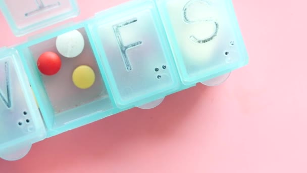 Крупним планом медичні таблетки і капсули в коробці для таблеток — стокове відео