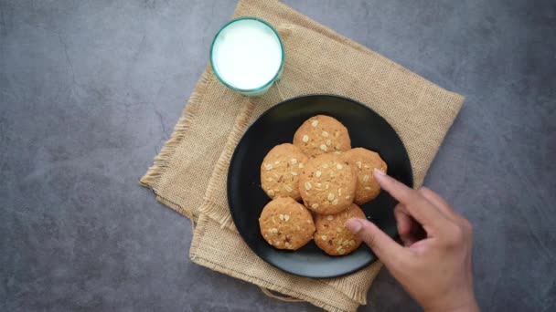 Χέρι πάρει ολόκληρο το γεύμα cookies σε μαύρο φόντο — Αρχείο Βίντεο