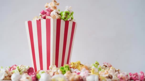 Popcorn verschüttet aus einem Papiercontainer auf hölzernem Hintergrund — Stockvideo