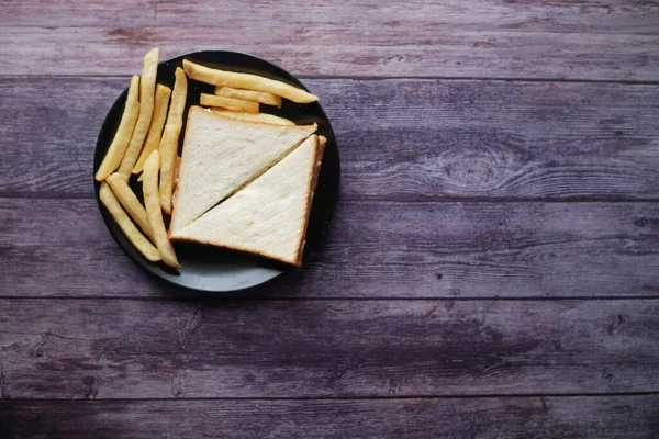 Yumurtalı sandviç ve patates kızartması tabakta. — Stok fotoğraf