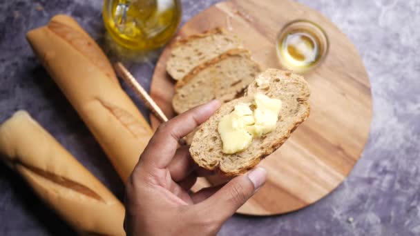Plátek másla a celozrnného chleba na sekané desce — Stock video