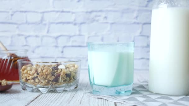 Desayuno de cereales en tazón, pan y miel sobre fondo blanco — Vídeos de Stock