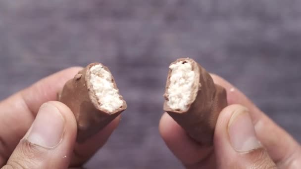 Trzymając czekoladę kokosową podzieloną na dwie części — Wideo stockowe
