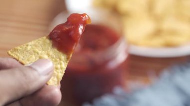 Acılı sosa batırılmış nachos. 