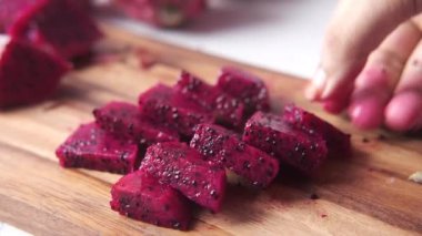 Bir dilim ejderha meyvesi doğrama tahtasında.