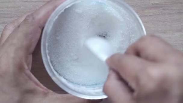 Witte suiker en lepel in een container op zwarte achtergrond, — Stockvideo
