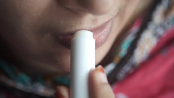 Женщина наносит увлажняющую помаду на губы — стоковое видео
