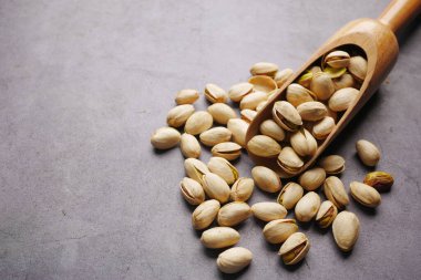 Tahta kaşıkta kaju fıstığı, siyah arka planda. 