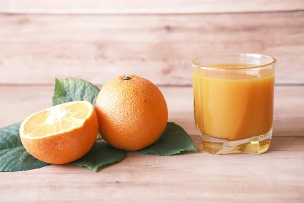 Vaso de zumo de naranja y naranja en la mesa — Foto de Stock