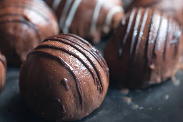 Forma redonda de chocolate negro en un plato sobre fondo rosa —  Fotos de Stock