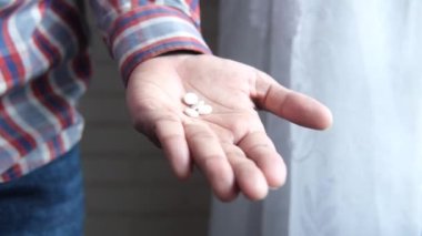 İlaç kutusundan dökülen ilaçlı adam eli. 