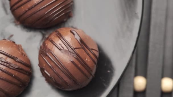 Круглая форма темный шоколад на тарелке на розовом фоне — стоковое видео