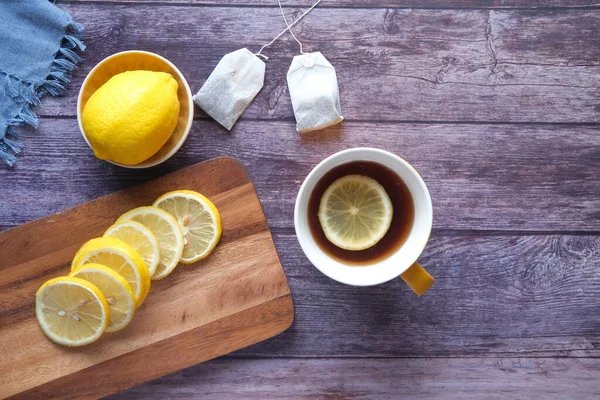 Vrchní pohled na citrónový čaj a plátek citronu na dřevěném pozadí. — Stock fotografie