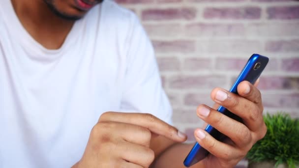 Primer plano de la mano del hombre joven usando el teléfono inteligente. — Vídeos de Stock