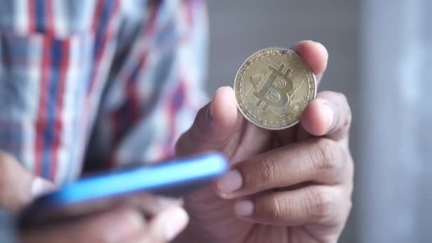 ダッカ・バングラデシュ2021年5月23日黄金のビットコインを持ちスマートフォンで — ストック動画