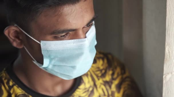 A young man with protective mask looking through window — Stock Video