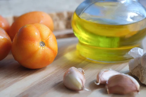 Close up of garlic , tomato and olive oil on table — Stock Photo, Image