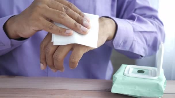 Pemuda membersihkan tangan dengan tisu basah di atas meja — Stok Video