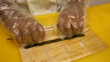 Genç aşçı masada suşi yapıyor..