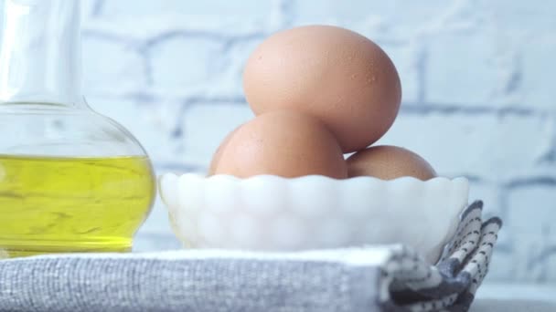 Perto de ovos em um boliche e óleo de cozinha em um jarro — Vídeo de Stock