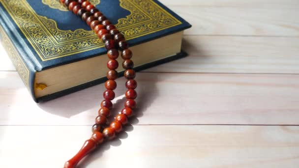Holy book Quran and rosary on table, close up. — Stock Video